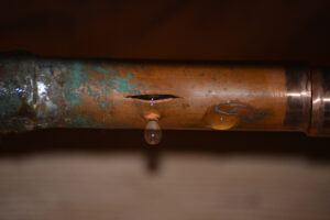 Corroded water pipe with a crack dripping water