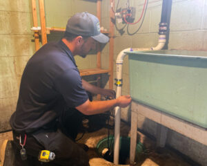 Dean's Home Services plumber working on a sump pump