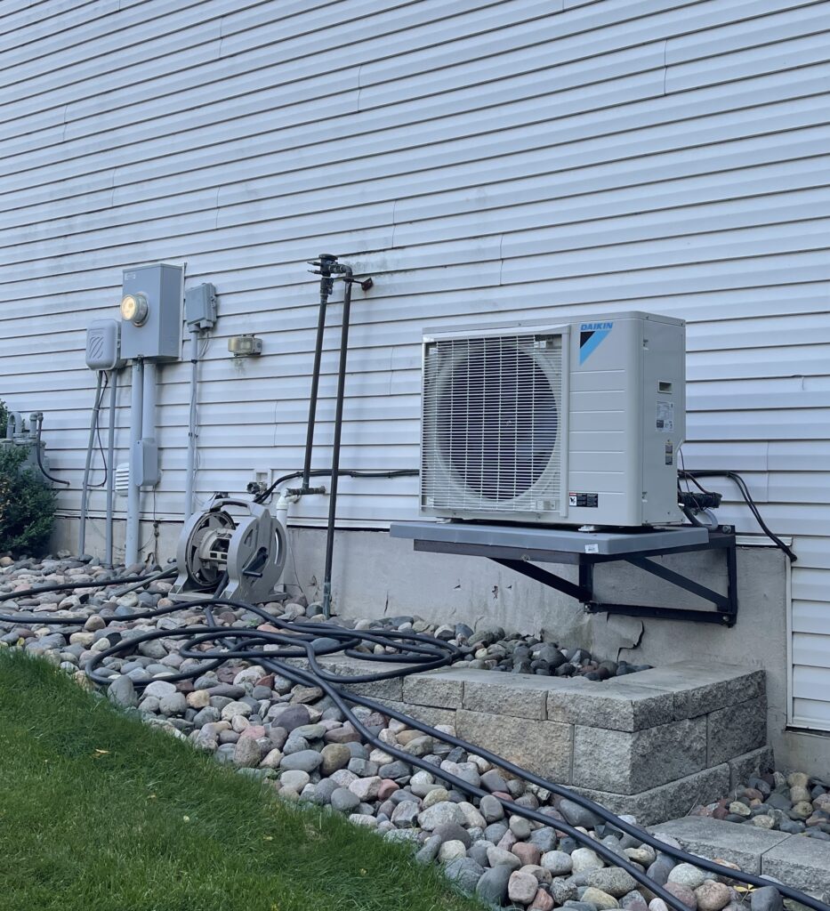 Heat pumps in Minnesota homes, home air source heat pump outside house 