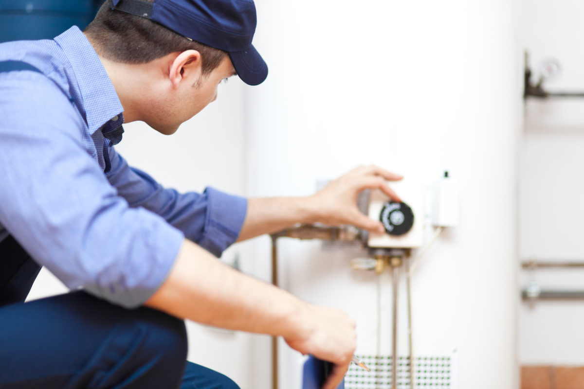 Plumber inspecting and servicing a water heater