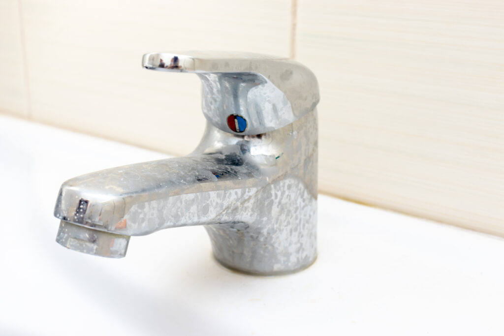 Dirty faucet with limescale buildup from hard water